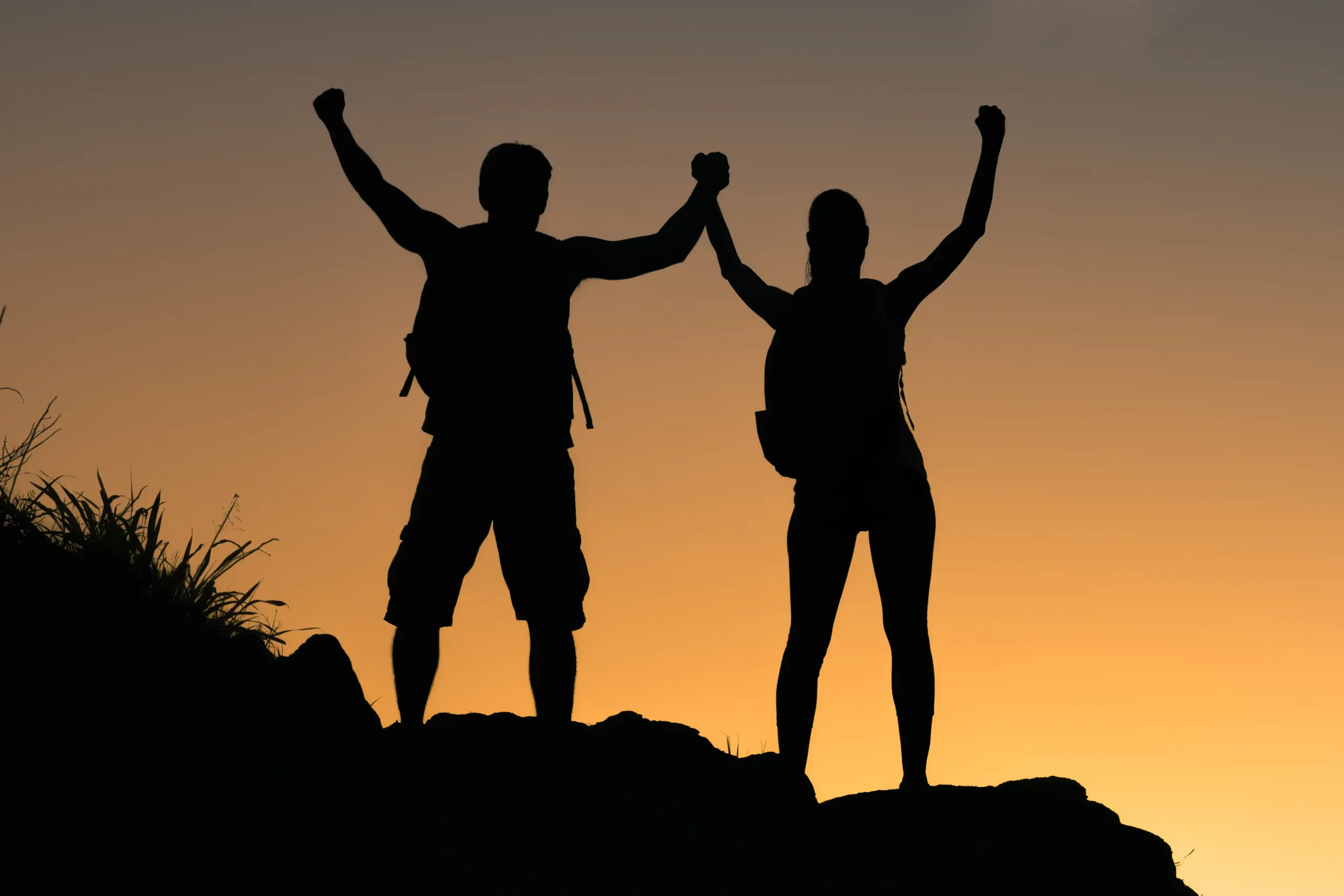 Tirzepatide-Doctor A man an a woman raise their arms in triumph at sunset after climbing to a mountain peak, celebrating weight loss due to tirzepatide treatments from Julie Kane, NP of Trua Health & Wellness in Alaska